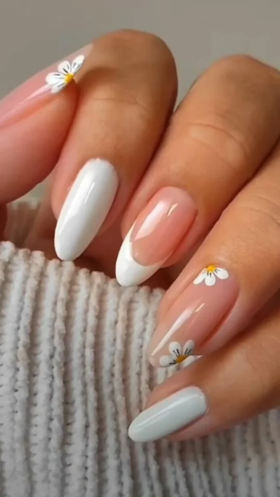 Pastel rainbow French tip spring nails with white daisy flowers on nude base