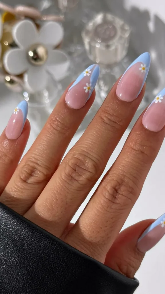 Soft pink daisy spring nails with tiny orange centers on almond manicure