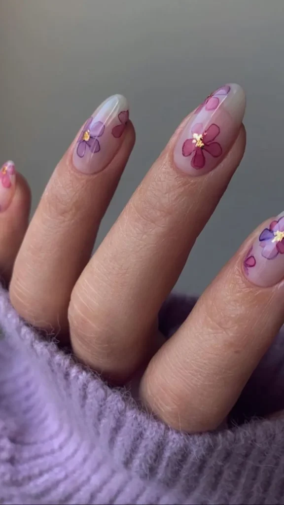 Soft pink daisy spring nails with tiny white and orange flowers on almond manicure
